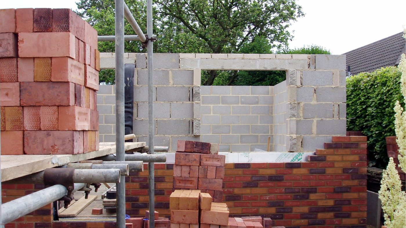 A surveyor inspecting brickwork on a property in West Sussex